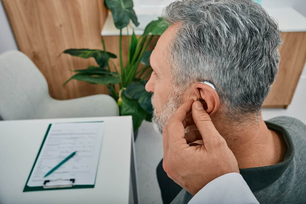 Man getting hearing aid fitted