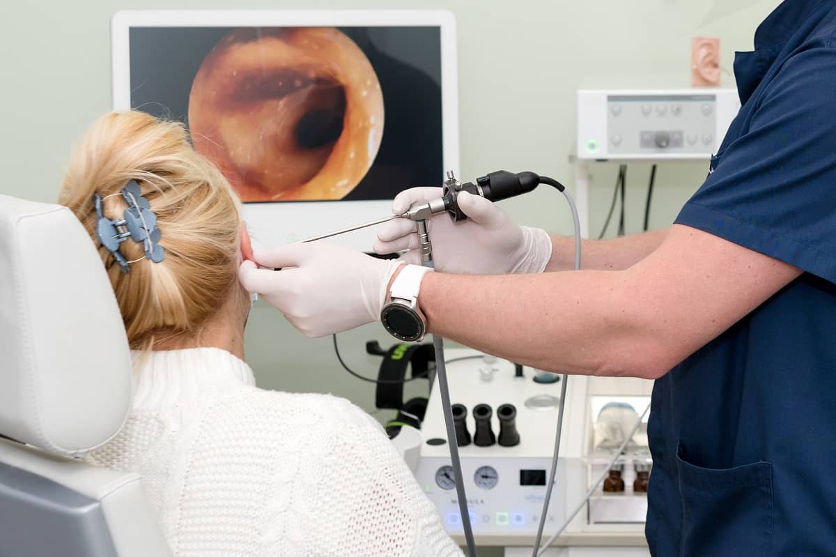 Woman having ear canal examined by audiologist